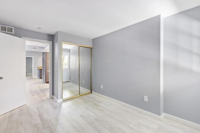 unfurnished bedroom with light wood-type flooring, visible vents, and baseboards