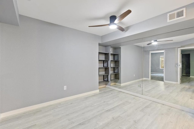 unfurnished bedroom with a ceiling fan, wood finished floors, visible vents, and baseboards