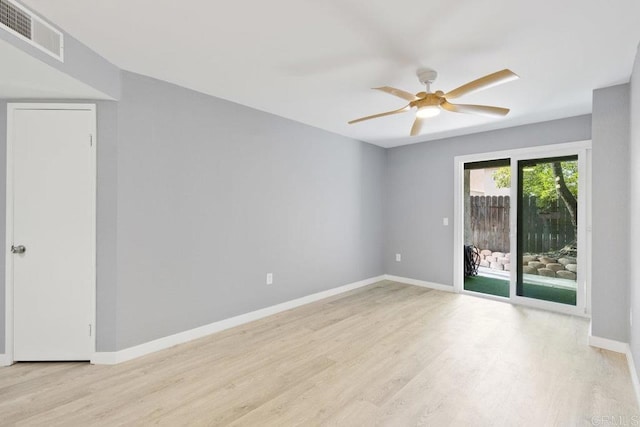 empty room with a ceiling fan, wood finished floors, visible vents, and baseboards