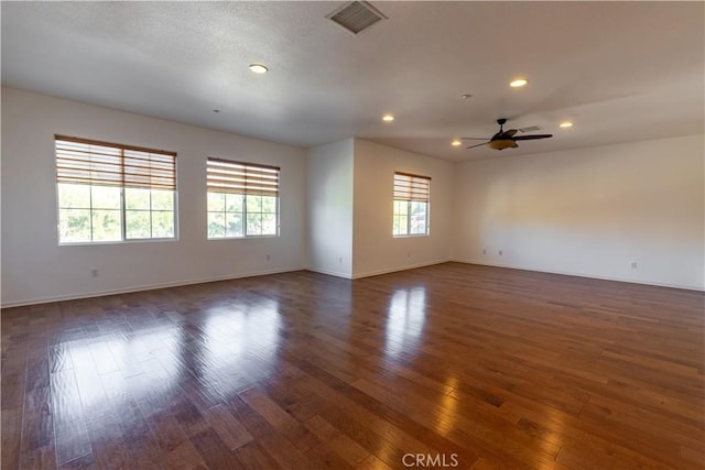 unfurnished room with ceiling fan, a healthy amount of sunlight, and dark hardwood / wood-style floors