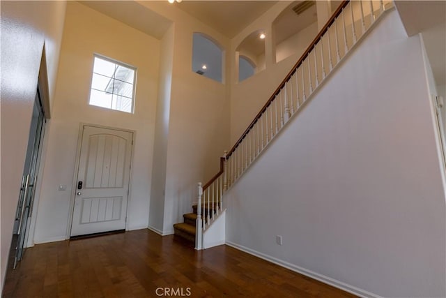 entryway with dark hardwood / wood-style floors and a high ceiling