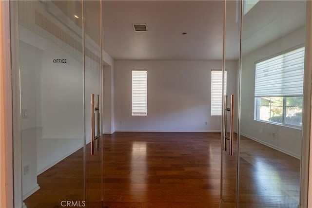 empty room with dark hardwood / wood-style flooring