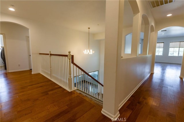 hall with dark hardwood / wood-style flooring and an inviting chandelier