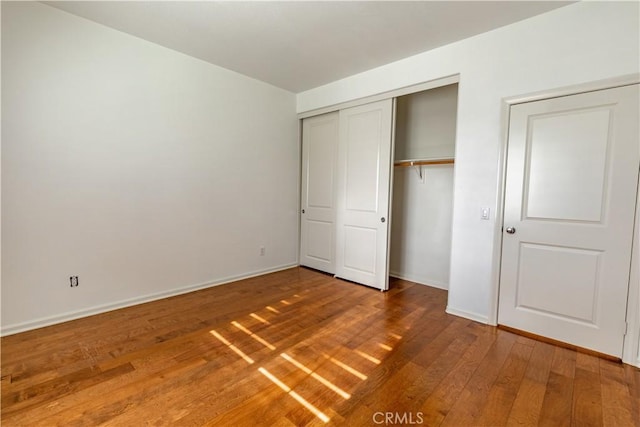 unfurnished bedroom with hardwood / wood-style flooring and a closet