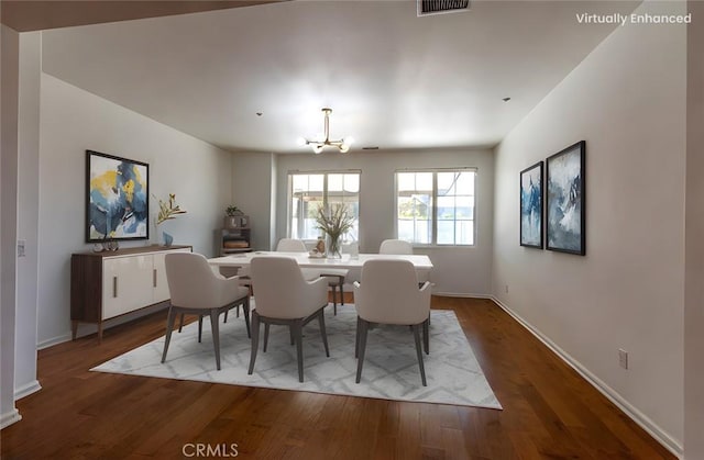 dining area with wood-type flooring and a chandelier