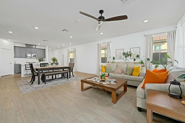 living room featuring ceiling fan and light hardwood / wood-style flooring