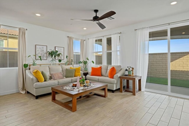 living room with ceiling fan, a healthy amount of sunlight, and light hardwood / wood-style flooring