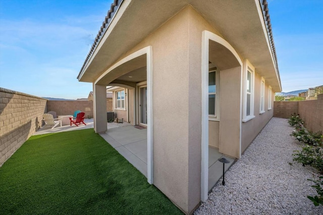 view of home's exterior with a yard and a patio