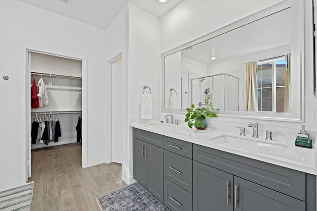 bathroom featuring hardwood / wood-style flooring, vanity, and a shower with shower door