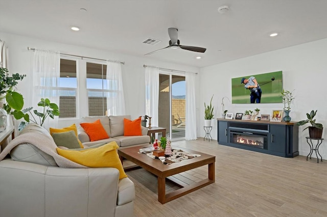 living room with light wood-type flooring and ceiling fan