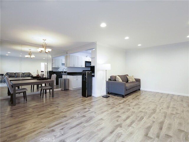 308 S Miraleste Dr Unit 57, San Pedro, CA 90732 - living room featuring a notable chandelier, crown molding, and light hardwood / wood-style flooring
