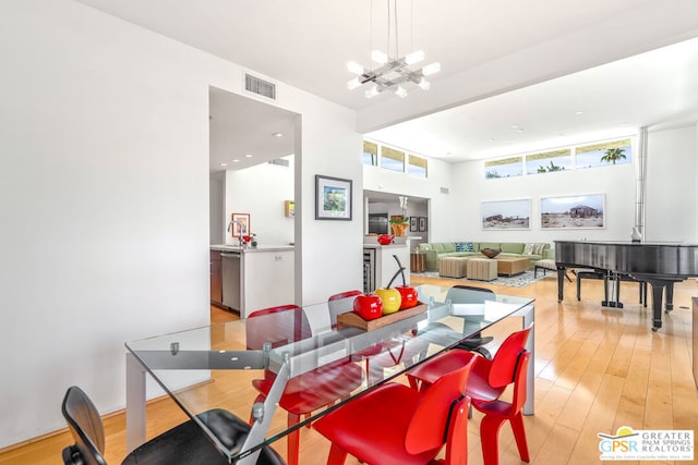 dining room with light hardwood / wood-style floors and a notable chandelier