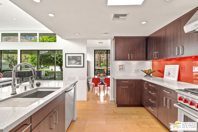 kitchen featuring stainless steel appliances, light hardwood / wood-style flooring, a wealth of natural light, and sink