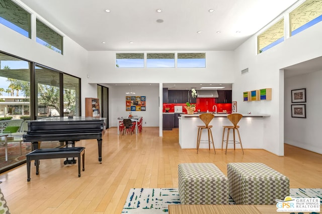 living room with plenty of natural light, a high ceiling, and hardwood / wood-style flooring