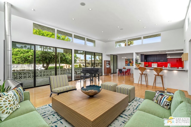 living room featuring a high ceiling and light wood-type flooring