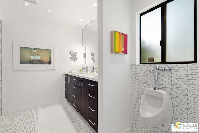 bathroom with tile patterned flooring, vanity, and tile walls