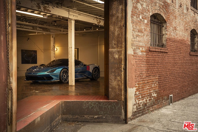 hall featuring concrete floors and brick wall