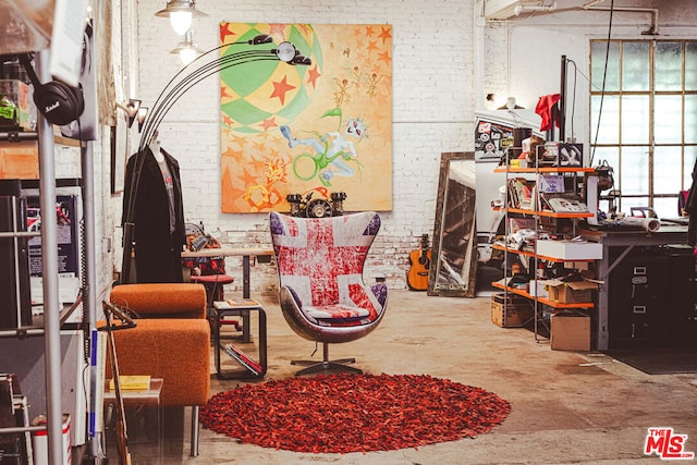 sitting room with concrete flooring and brick wall