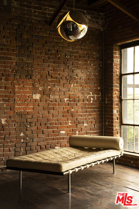 interior space featuring plenty of natural light, wood-type flooring, and brick wall