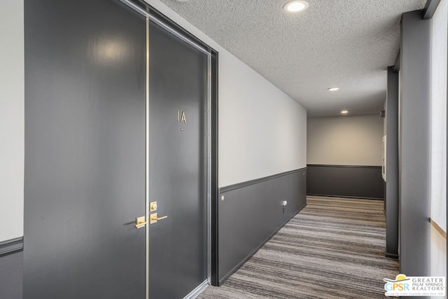 hall with carpet and a textured ceiling