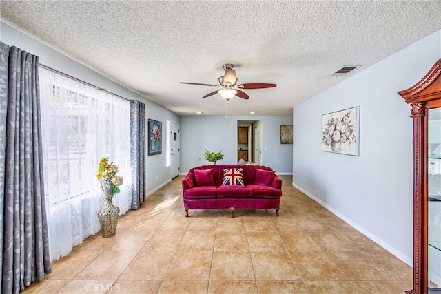 living room with light tile patterned floors, a textured ceiling, and ceiling fan