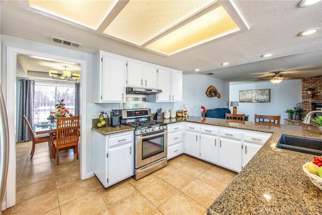 kitchen with stone countertops, white cabinetry, sink, kitchen peninsula, and gas range