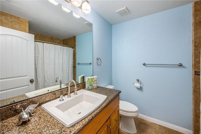 bathroom featuring vanity, tile patterned flooring, and toilet