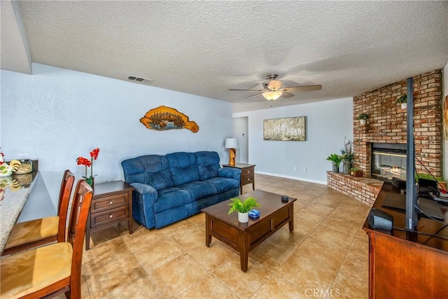 tiled living room featuring a brick fireplace, a textured ceiling, and ceiling fan