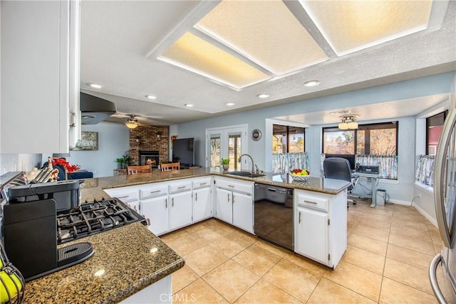 kitchen with sink, dark stone countertops, black dishwasher, kitchen peninsula, and white cabinets