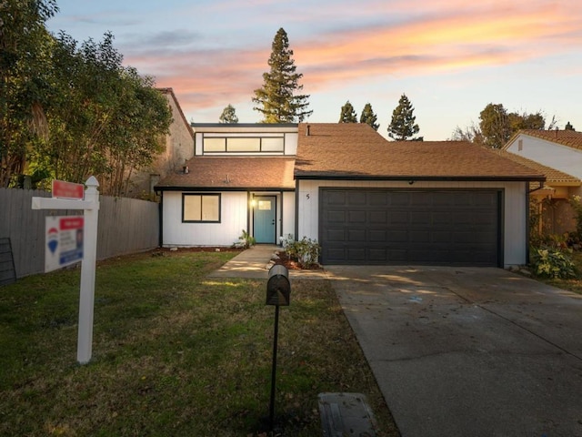 view of front of house with a garage and a yard