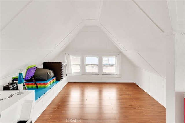 additional living space with hardwood / wood-style flooring and vaulted ceiling