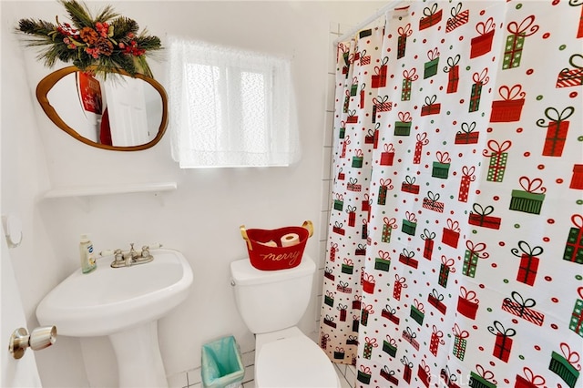 bathroom featuring a shower with curtain and toilet