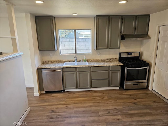 kitchen with stainless steel appliances, sink, hardwood / wood-style floors, and gray cabinets