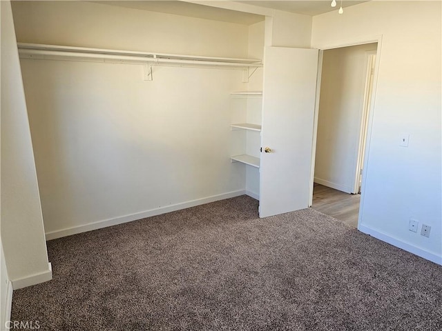 unfurnished bedroom featuring dark colored carpet and a closet