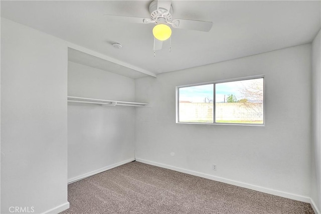 carpeted spare room featuring a ceiling fan and baseboards