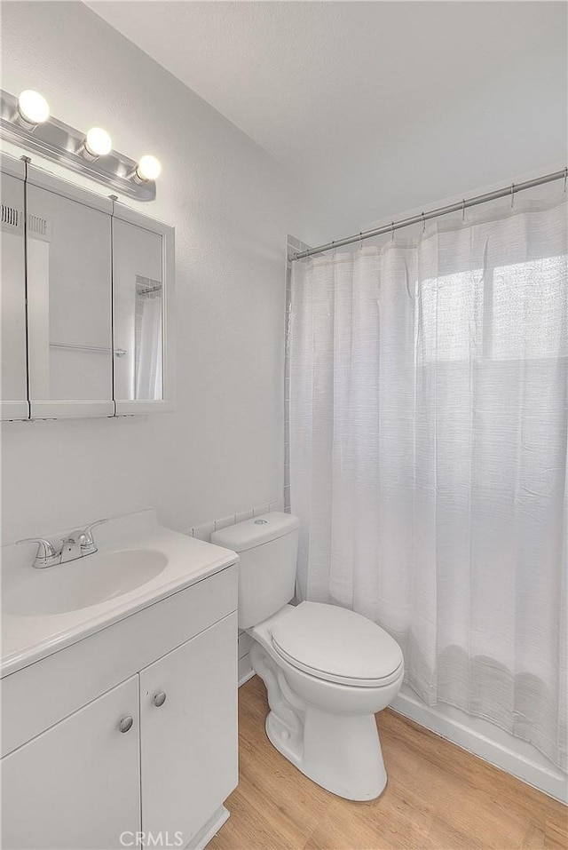 full bath featuring vanity, toilet, and wood finished floors