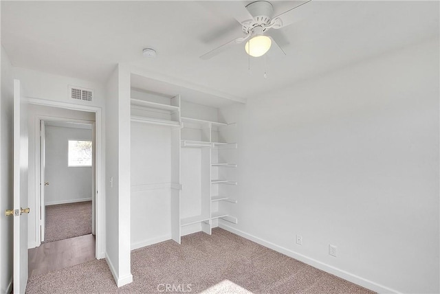 unfurnished bedroom featuring a ceiling fan, carpet flooring, baseboards, and a closet