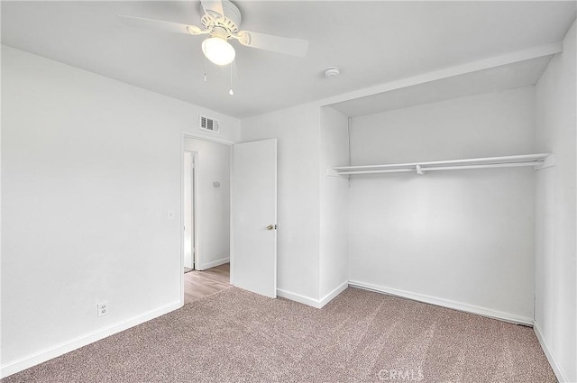 unfurnished bedroom with a ceiling fan, carpet flooring, baseboards, and visible vents