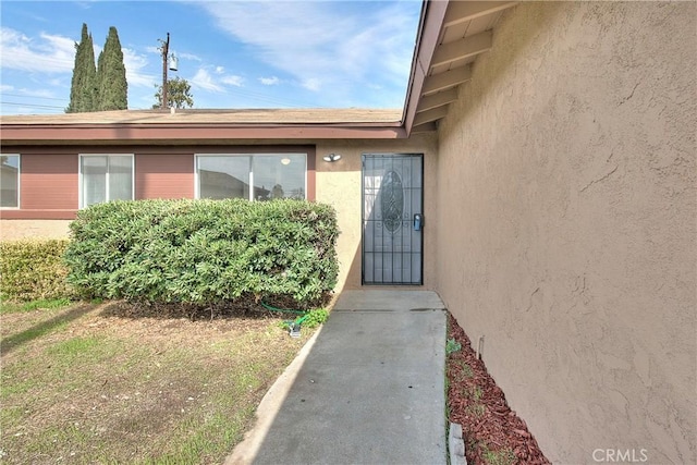 entrance to property featuring stucco siding