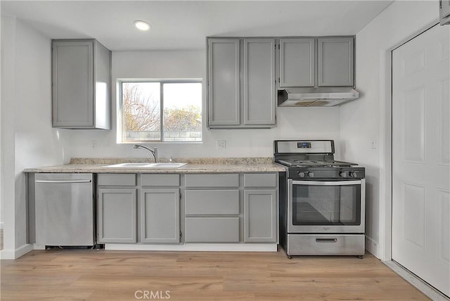 kitchen with appliances with stainless steel finishes, gray cabinets, and under cabinet range hood