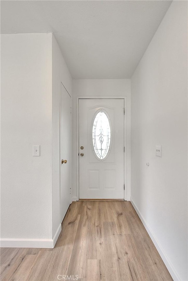 foyer entrance featuring light wood finished floors and baseboards