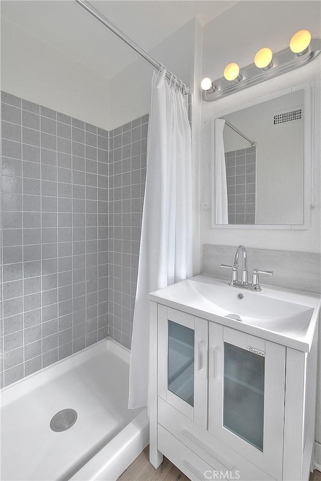 bathroom featuring vanity and a tile shower