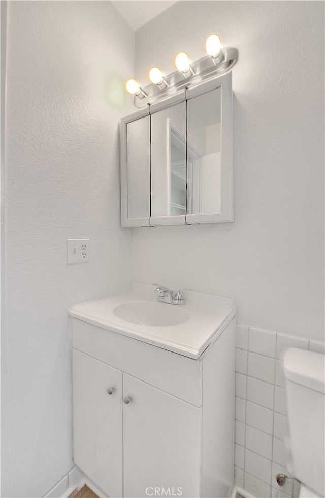 half bathroom with vanity and toilet