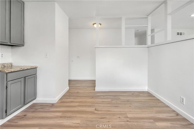 unfurnished dining area featuring visible vents, baseboards, and light wood-style floors