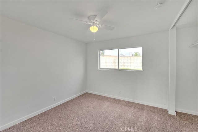 carpeted empty room with baseboards and a ceiling fan