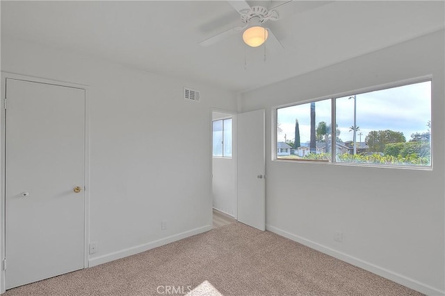 unfurnished bedroom with a ceiling fan, baseboards, visible vents, and carpet floors