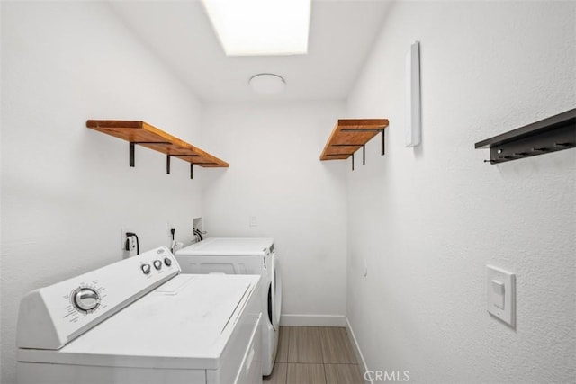 laundry area featuring light tile patterned floors and washing machine and dryer