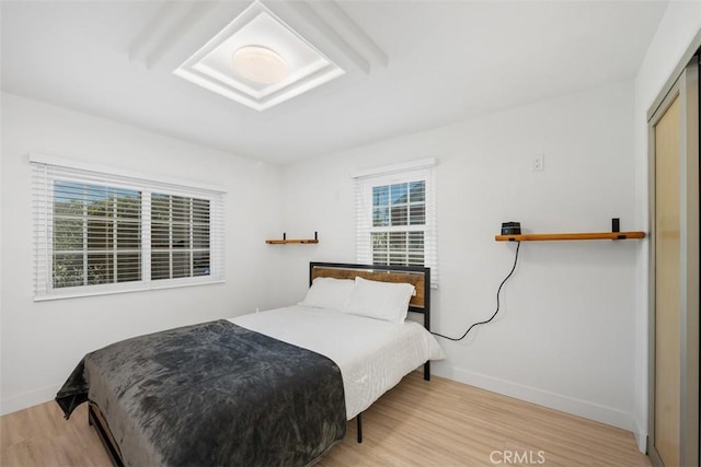 bedroom featuring light wood-type flooring and multiple windows