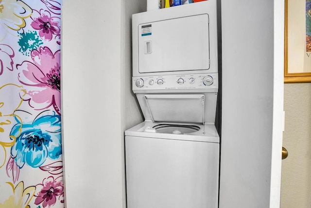 washroom with stacked washing maching and dryer