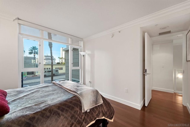 bedroom with ornamental molding and dark wood-type flooring